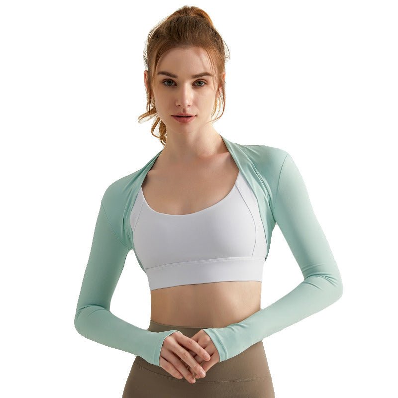 Woman wearing a light green long - sleeve athletic top over a white sports bra on a white background
