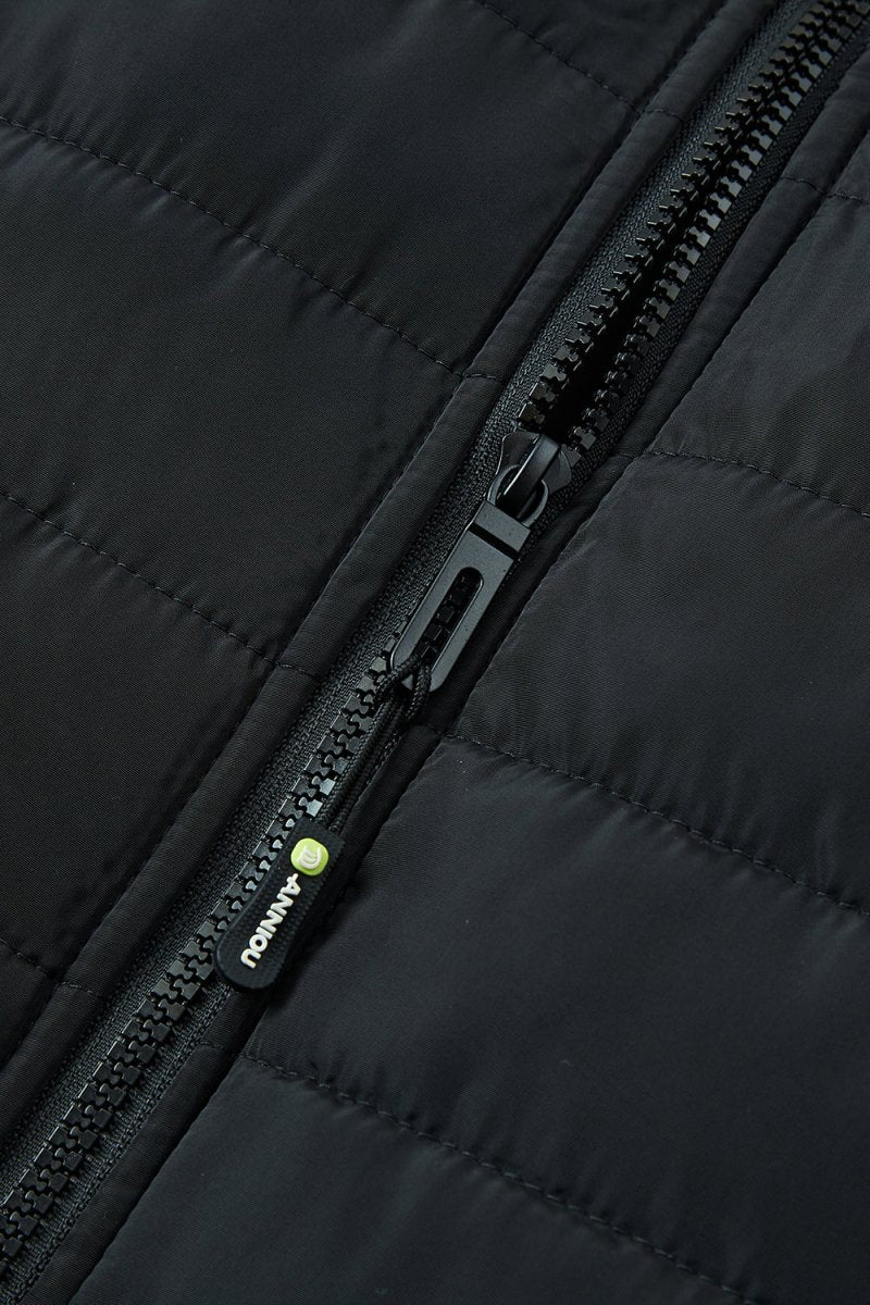 Close-up of a black quilted heated vest with a black zipper and a small green-and-white ANNIOU logo.
