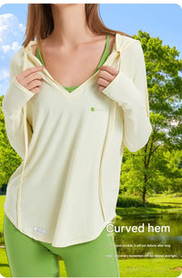 Woman wearing a upf 100+  light-colored jacket and green pants in a park setting