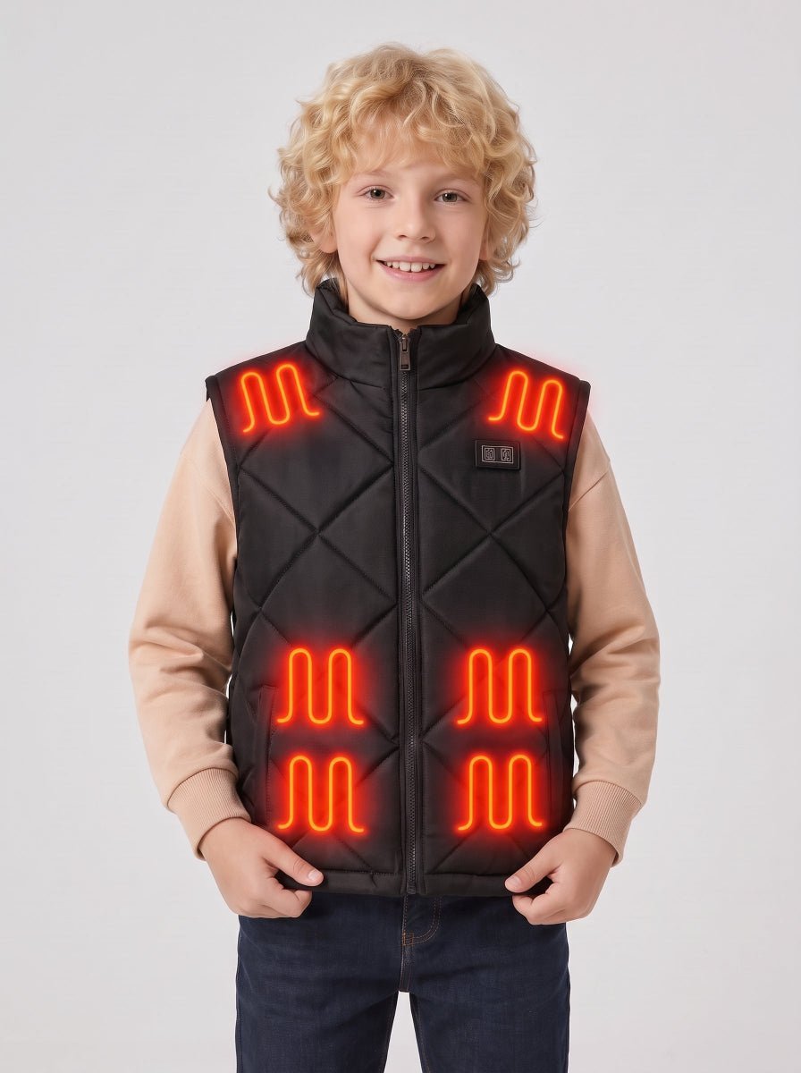 Boy model showing full front of black quilted kids heated vest, hands holding vest hem, visible glowing red heating pads