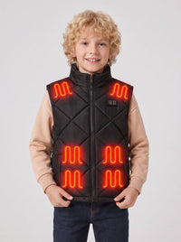 Boy model showing full front of black quilted kids heated vest, hands holding vest hem, visible glowing red heating pads