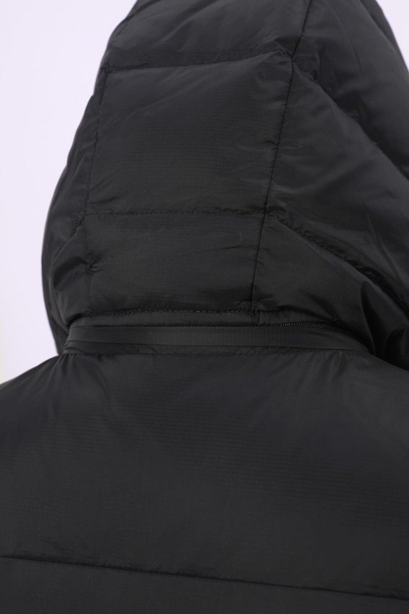 Close-up of the hood and upper back of a black puffer vest, showing quilted stitching and a zippered hood detail