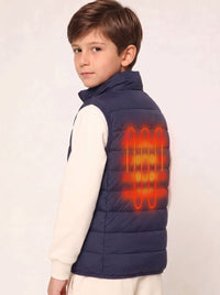 A young boy wearing a navy blue puffer vest over a cream long-sleeve shirt, shown from the back. The vest features a glowing orange graphic overlay representing a built-in heating element on the back.