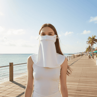 Woman wearing a white face shield on a beach boardwalk