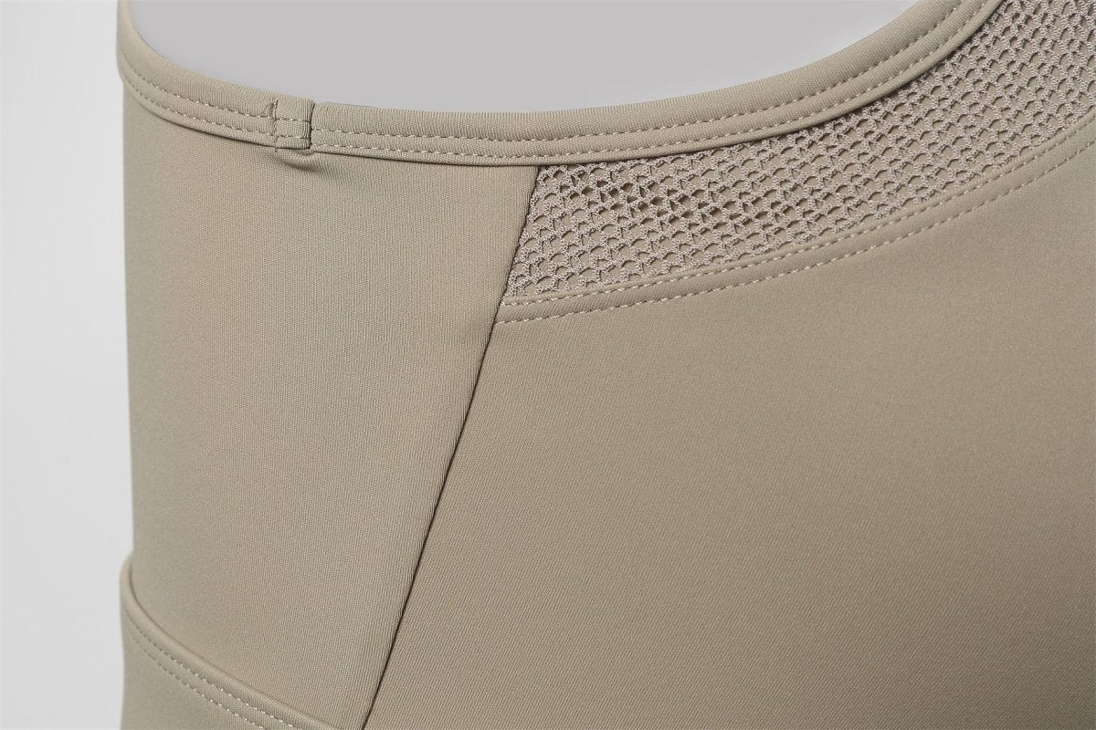 Close - up of beige compression garment with mesh panel on a light gray background