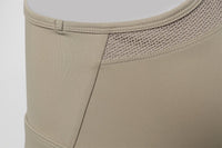 Close - up of beige compression garment with mesh panel on a light gray background