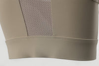 Beige sports bra with mesh panel on a light gray background