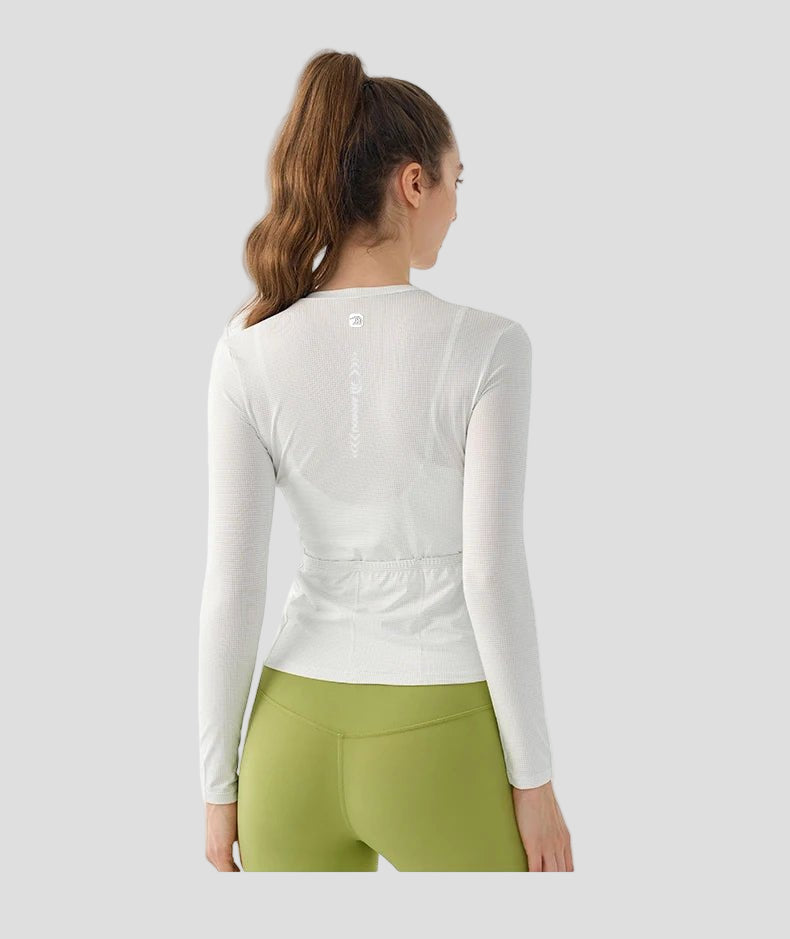 Woman wearing a white long - sleeve top and green leggings on a white background