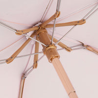 Close - up of an umbrella's metal frame on a light pink background