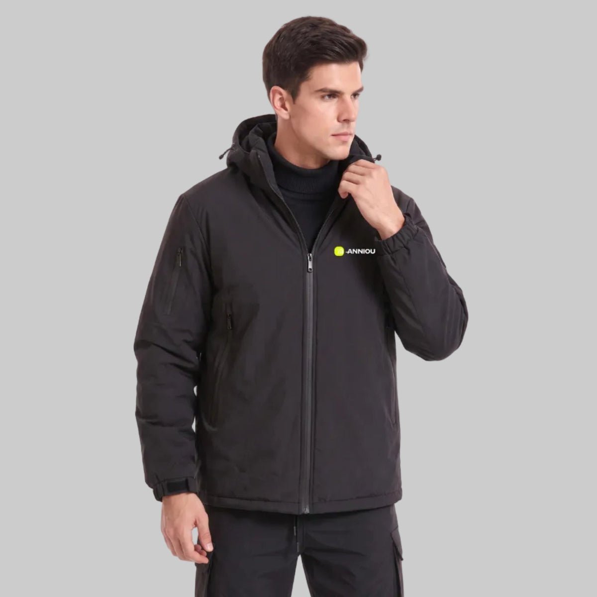 Young British male model adjusting hood collar of ANNIOU black tactical hooded softshell jacket