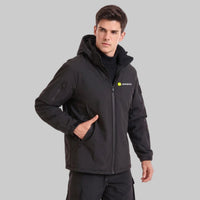 Young British male model wearing ANNIOU black hooded tactical softshell jacket, one hand in side pocket,