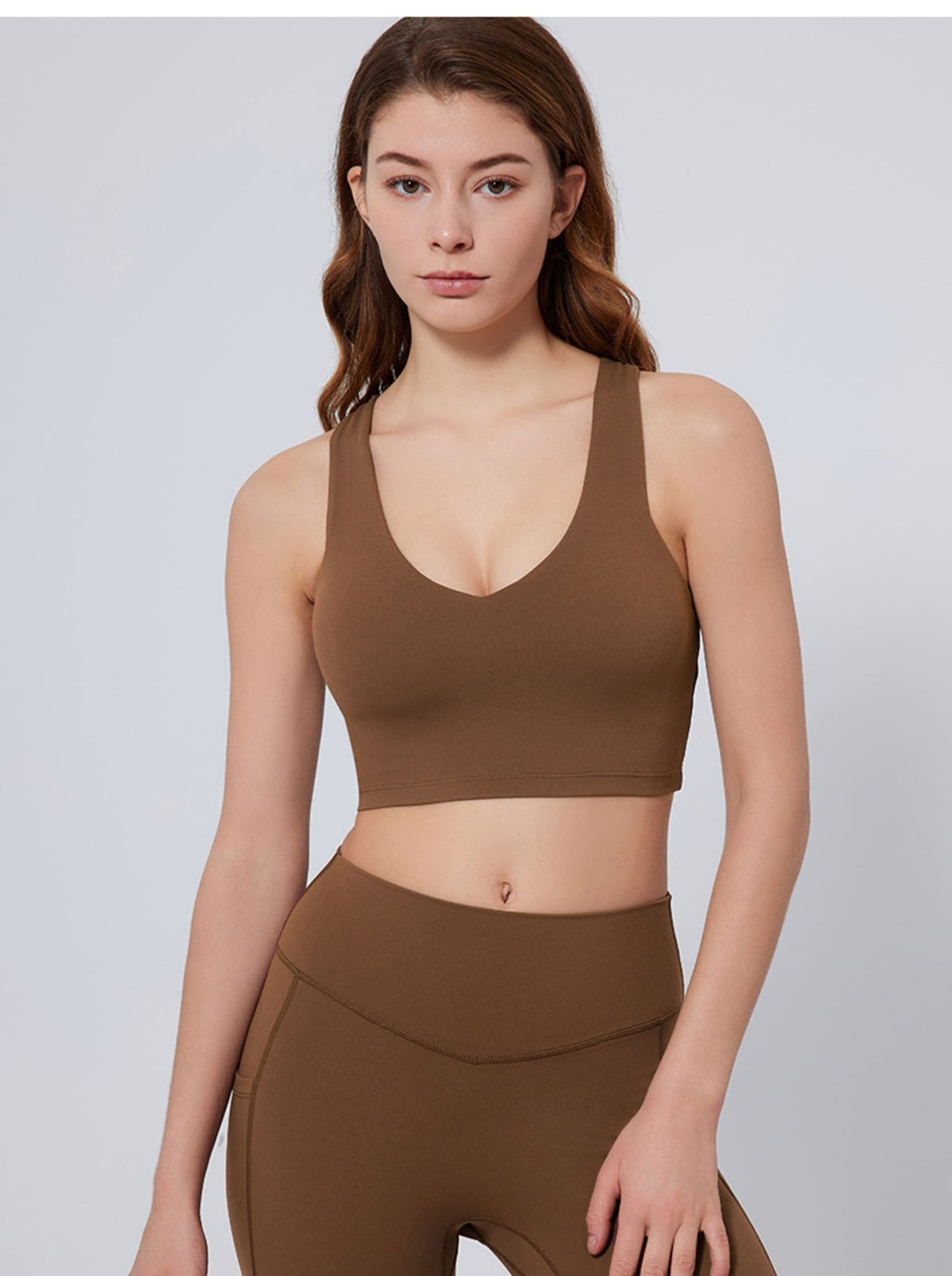Woman wearing a mocha UPF 50+ sports bra and leggings