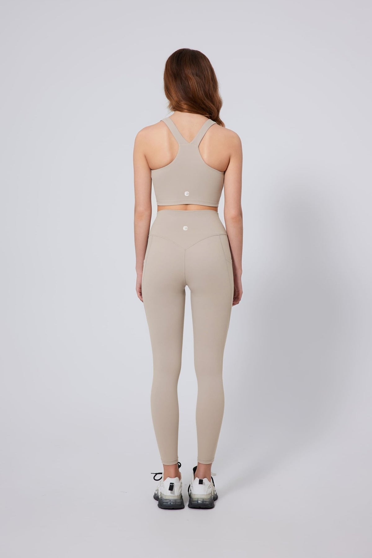 Woman wearing a Anniou beige sports bra and leggings set on a white background