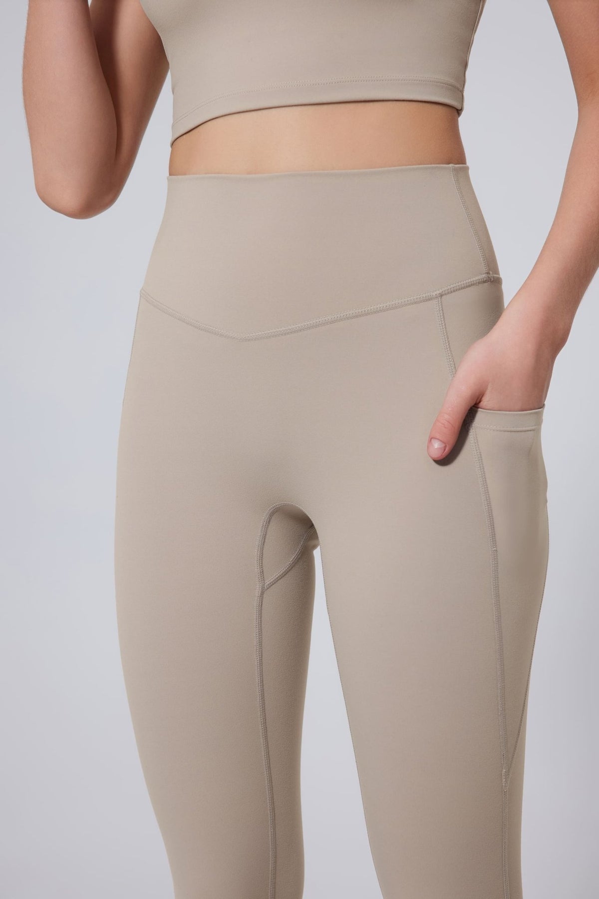 Beige leggings worn by a person on a light gray background