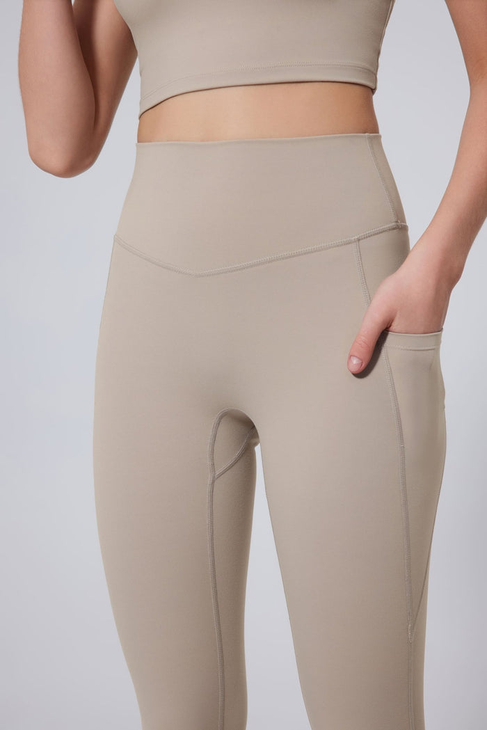 Beige leggings worn by a person on a light gray background