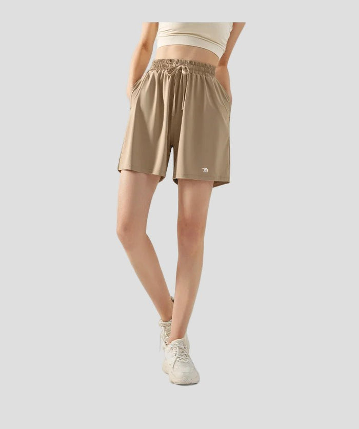 Person wearing beige sun protection shorts on a white background