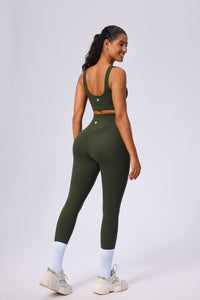 Woman wearing a green sports outfit on a light gray background