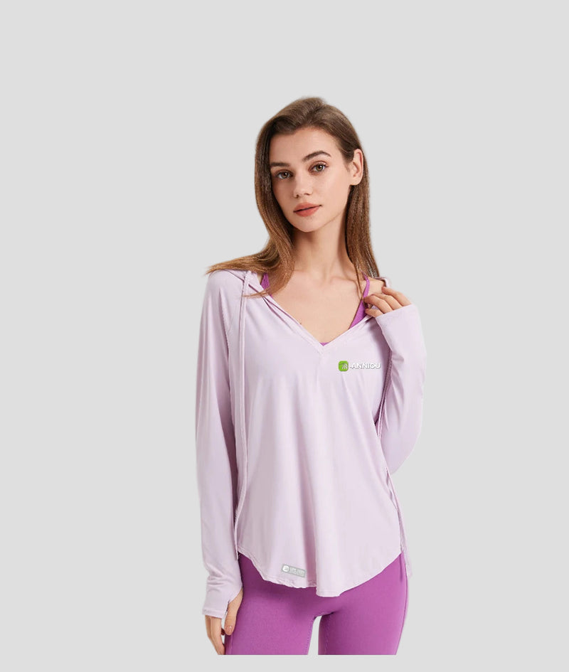Woman wearing a light pink long-sleeve sun protection athletic top with a logo on a white background