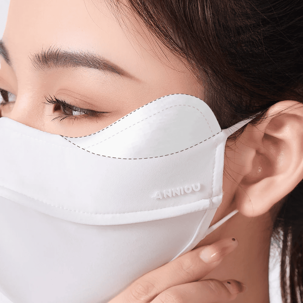 Close - up of a person wearing a white face mask with 'ANNIOU' branding.