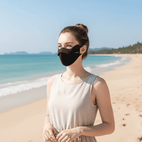 Woman on a beach wearing a black Lycra UV Face Mask upf 50+