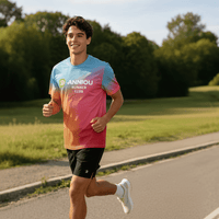 A young man wearing a rainbow gradient T-shirt is jogging in an outdoor park.