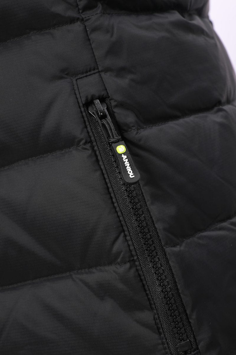 Close-up of a black puffer jacket showing a quilted panel and a black zipper with a small yellow-green brand tab reading ANNIOU.