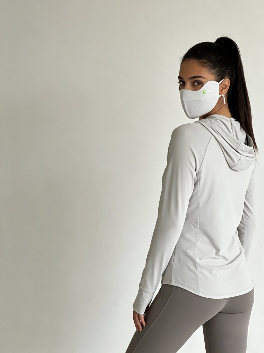 Woman wearing a light gray silk uv mask