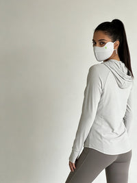 Woman wearing a light gray silk uv mask
