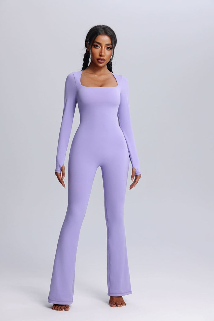 Woman wearing a lavender yoga jumpsuit on a plain background