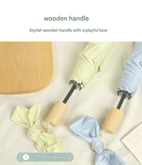 Three umbrellas with wooden handles and playful bows on a light background