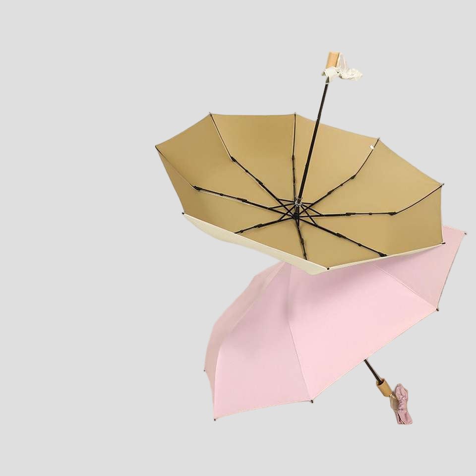 Two umbrellas, one beige and one pink, on a light gray background
