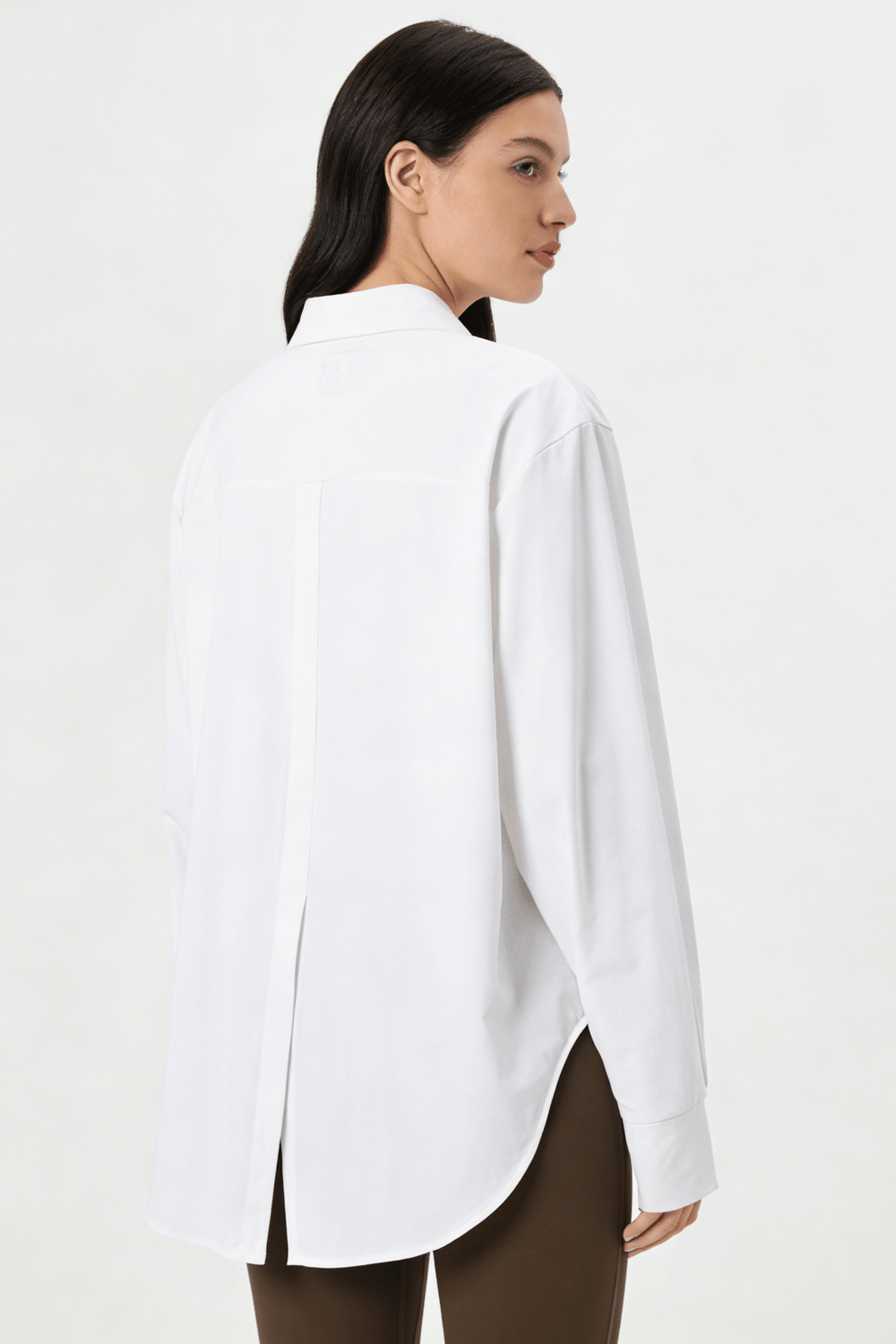 Woman wearing a white shirt with a plain background