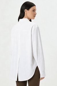 Woman wearing a white shirt with a plain background