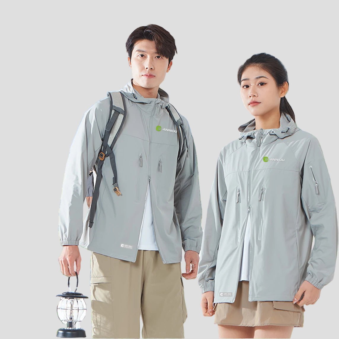 Two people wearing gray upf 100 sun protection jackets with a scenic background