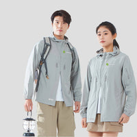 Two people wearing gray upf 100 sun protection jackets with a scenic background