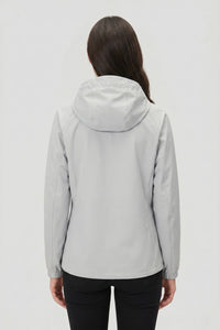 Person wearing a light gray hooded jacket on a white background