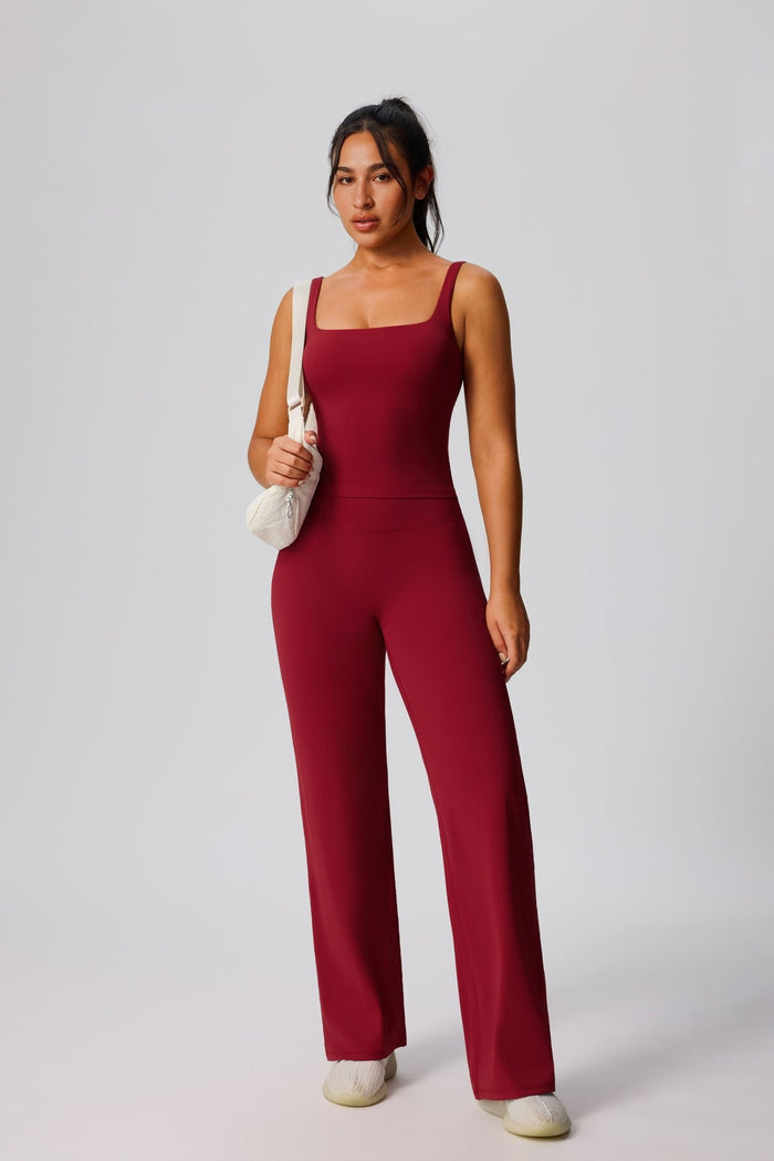 Woman wearing a red yoga set against a plain background