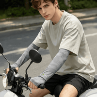 A man wearing gray loose - fitting sun protection sleeves while riding a bicycle