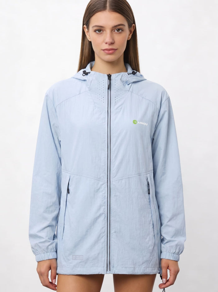 A woman wearing a light blue UV protection hooded jacket with a full front zipper and a green and white Anniou logo on the left chest, and breathable vents