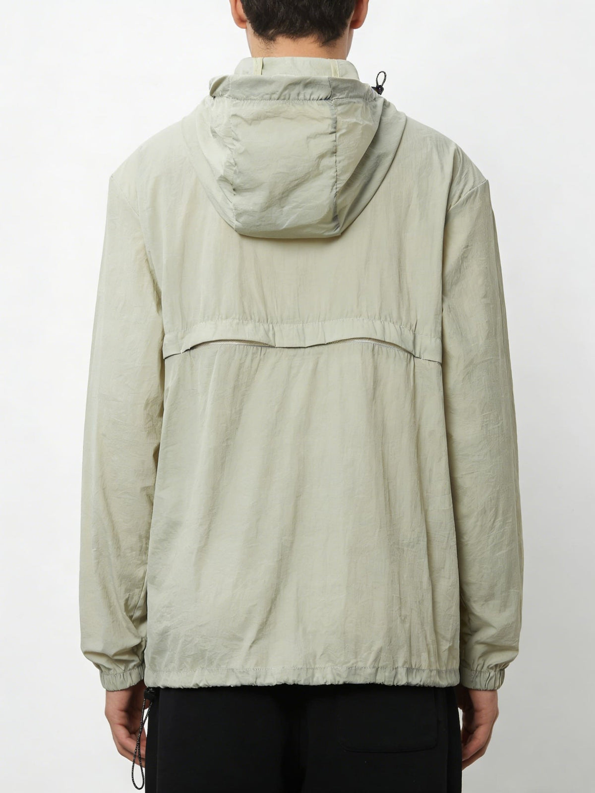 Person wearing a light green jacket with a hood on a white background