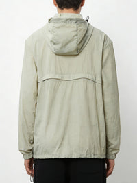 Person wearing a light green jacket with a hood on a white background