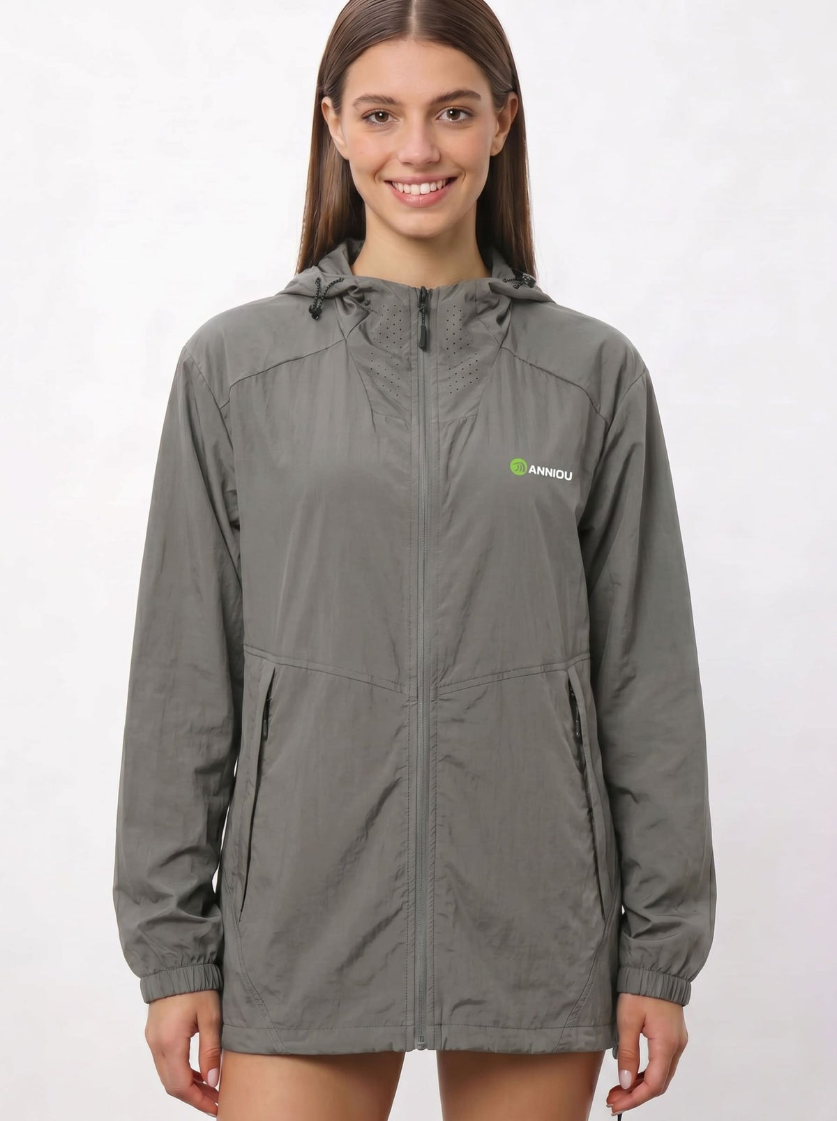 A woman wearing a gray UV protection hooded jacket with a full front zipper and a green and white Anniou logo on the left chest, and breathable vents