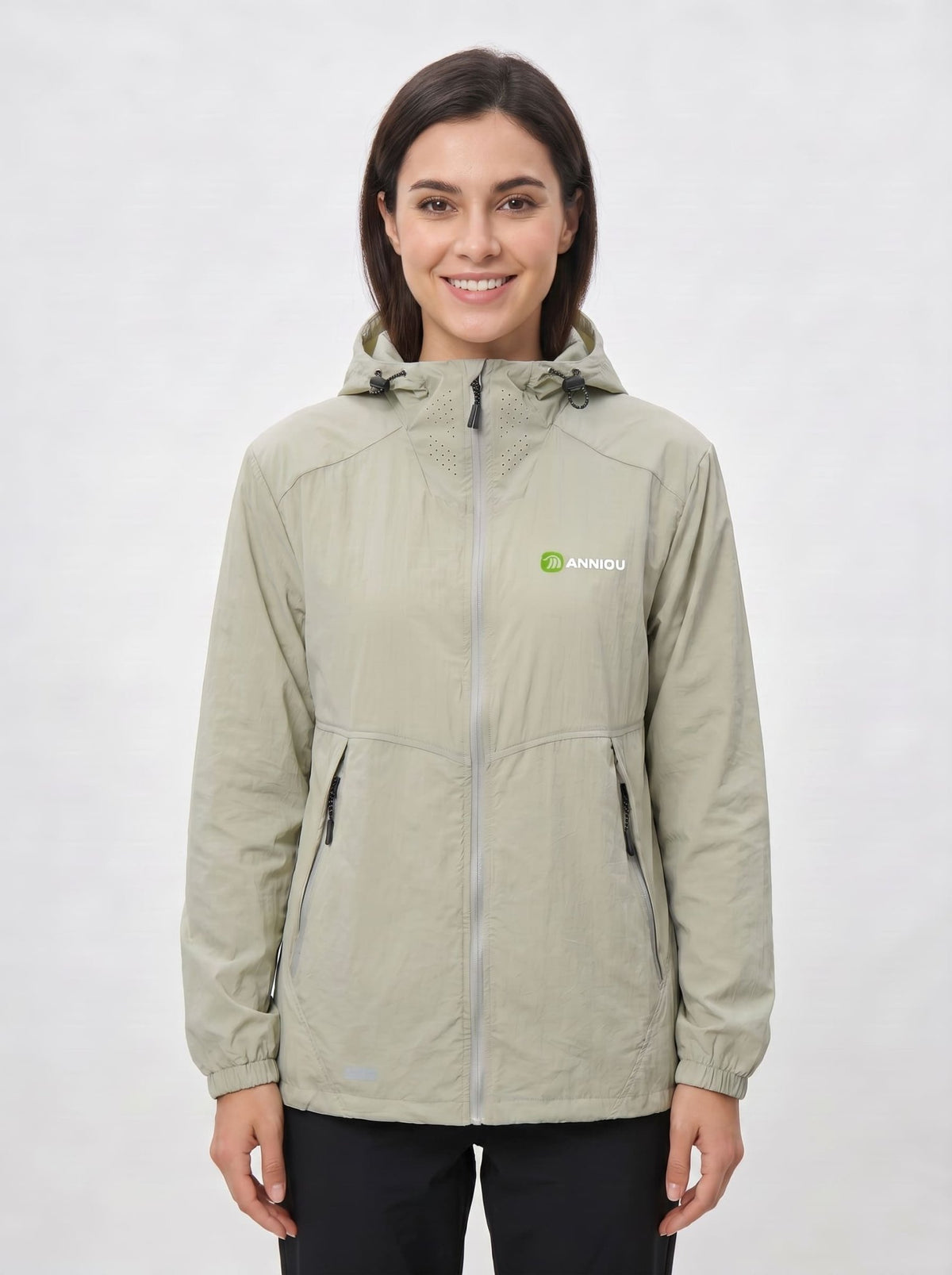 A woman wearing a light green UV protection hooded jacket with a full front zipper and a green and white Anniou logo on the left chest, and breathable vents