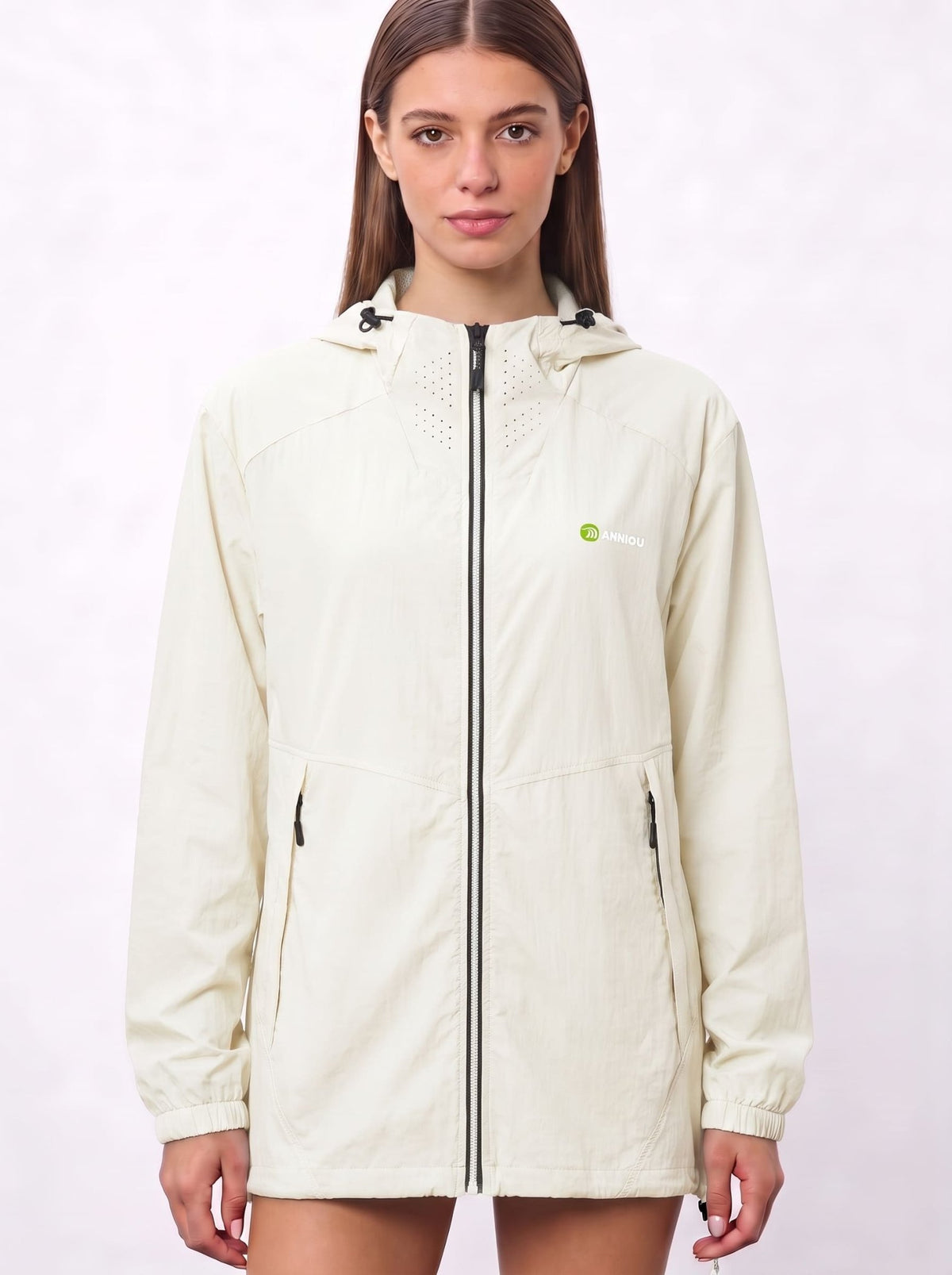 A woman wearing a white cream UV protection hooded jacket with a full front zipper and a green and white Anniou logo on the left chest, and breathable vents