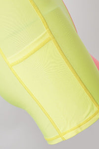 Close - up of a bright yellow fabric with a pink object partially visible