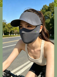 Woman cycling with a dark gray UV Wide Brim Face Mask UPF50+