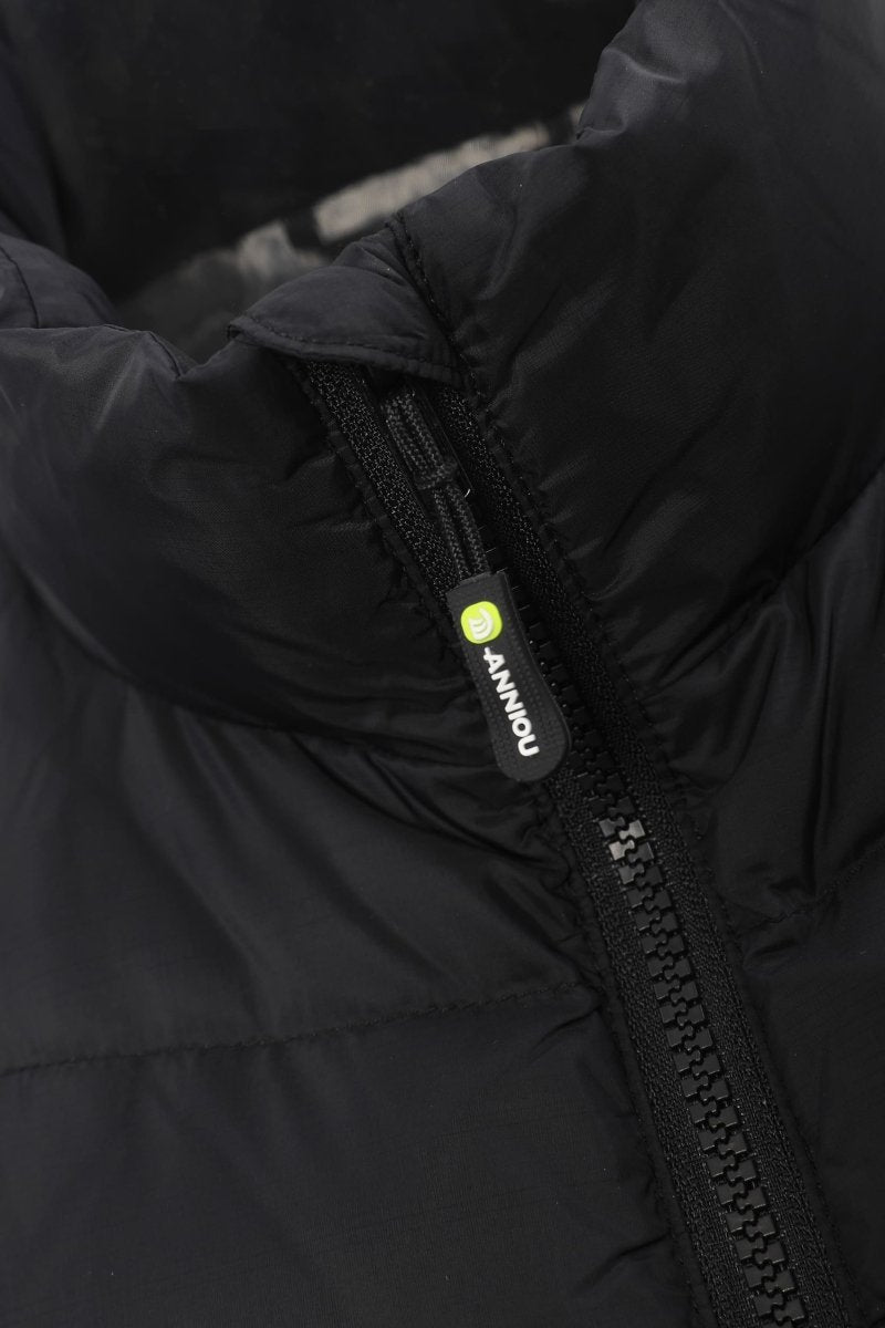 Close-up of a black puffer jacket showing the high collar, quilted fabric texture, and a black zipper pull with a small yellow-green circular logo and white 'ANNIOU' text.
