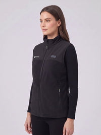 A woman wearing a black zip-front fleece heated vest over a black long-sleeve top.