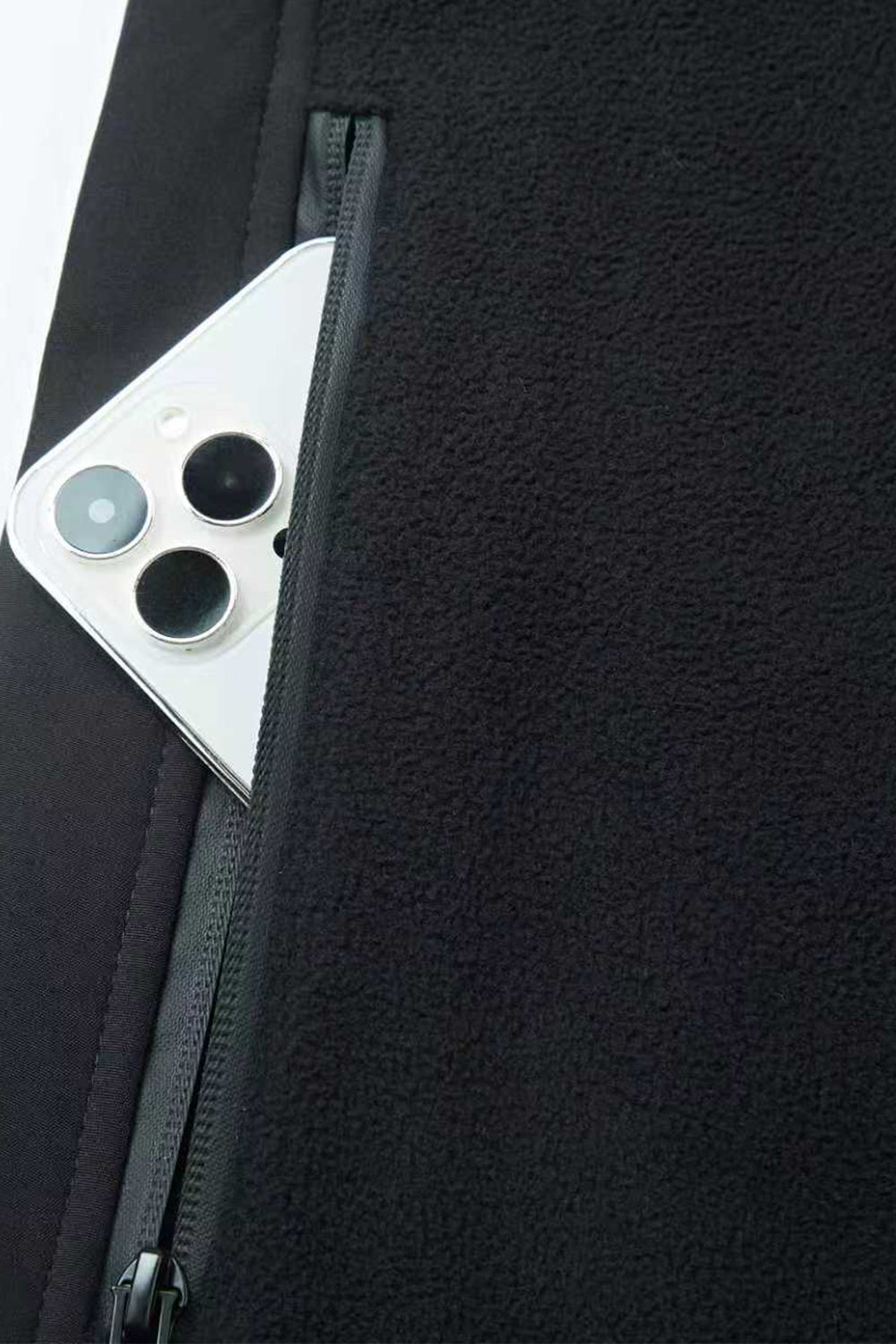 Close - up of a smartphone with a black case and zipper, against a dark background.