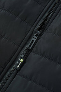 Close-up of a black quilted heated vest with a black zipper and a small green-and-white ANNIOU logo.